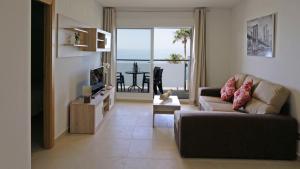 a living room with a couch and a view of the ocean at As Apartamentos Turisticos in El Morche