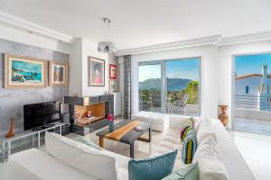 uma sala de estar com um sofá branco e uma televisão em luxurious house near the sea em Porto Rafti
