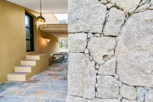 a stone wall in the hallway of a house at Hôtel confidentiel Le Grecale in Pianottoli-Caldarello