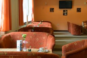 una sala de espera con sillas naranjas y una mesa con una mesa en Hotel SOREA ĎUMBIER, en Liptovský Ján