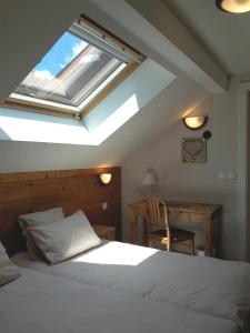 1 dormitorio con 1 cama y tragaluz en Le Brabant Bar-Hôtel-Restaurant, en La Bresse