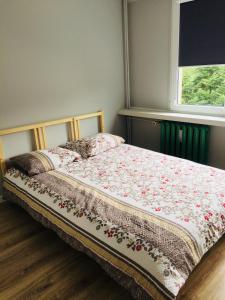 a bed with a floral comforter on it in a bedroom at Apartament Halinka salon, sypialnia, kuchnia, balkon Powierzchnia 50m in Krynica Zdrój