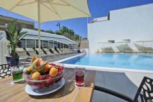 a bowl of fruit on a table next to a pool at Joli Park Hotel - Caroli Hotels in Gallipoli