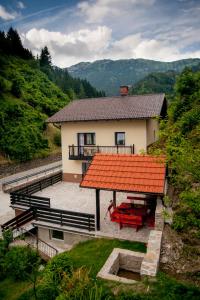 una casa con techo naranja y banco rojo en House Utrinek with free play room, jacuzzy and garage, en Podbrdo