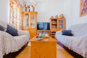 ein Wohnzimmer mit 2 Sofas und einem Couchtisch in der Unterkunft Casa Mariana in Conil de la Frontera