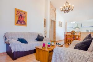 ein Wohnzimmer mit einem Sofa und einem Tisch in der Unterkunft Casa Mariana in Conil de la Frontera