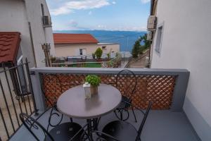 einen kleinen Tisch und Stühle auf dem Balkon in der Unterkunft Apartments Tara in Vrbnik