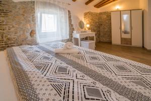 - une chambre avec un grand lit et un mur en pierre dans l'établissement Apartments Tara, à Vrbnik