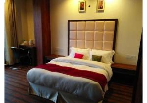 a bedroom with a large bed with a large headboard at Exotic Kufri stay with Incredible Views in Kūfrī