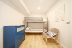 ヒホンにあるApartamento Centro-Playa IIのベッドルーム1室(二段ベッド1組、青いドレッサー、椅子付)
