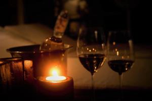 tres copas de vino y una vela en una mesa en ABORIGEN APARTAMENTOS BOUTIQUE en Puerto Madryn