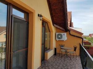 a balcony of a house with a table and chairs at La Siesta Apartments Oradea in Oradea