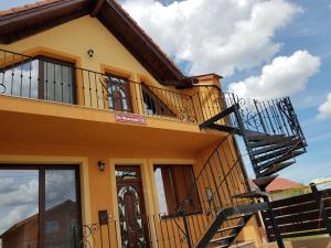 a yellow house with a balcony at La Siesta Apartments Oradea in Oradea