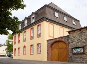 ein großes gelbes Gebäude mit braunem Dach in der Unterkunft Pension Martinerhof in Wintrich