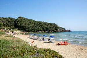 plaża z leżakami i parasolami oraz samolot na piasku w obiekcie Torre San Vito Hotel Villaggio w mieście Gaeta