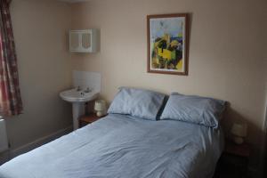 a bedroom with a bed and a sink and a picture at Ishara Apartment in Weymouth