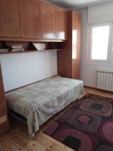 a bedroom with a bed with a rug and a window at Laredo-Colindres in Colindres