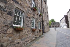 a stone building with windows and potted plants on it at Mar Apartment in Stirling