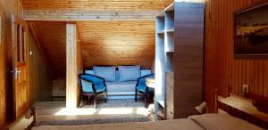 um quarto com cadeiras azuis num chalé de madeira em Kotedžas prie pušelių em Nida