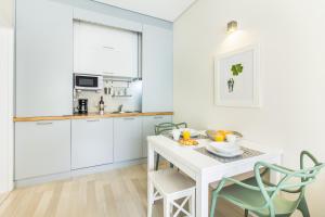 ポルトにあるSanta Catarina Modern Flatの白いキャビネット、白いテーブルと椅子付きのキッチン