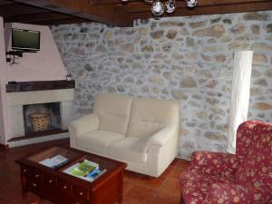 a living room with a chair and a fireplace at Casa Iris in Narciandi