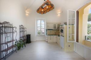 una cocina con armarios blancos y una lámpara de araña en Villino Emanuele, en Santa Marinella