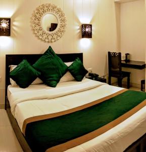 um quarto com uma cama com almofadas verdes e um espelho em La Casa em Haridwar