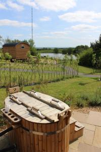 una bañera de madera en un patio con una valla en Fair Farm Hideaway en Waltham on the Wolds