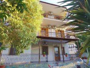 a large white building with a balcony and trees at Studios Kentia in Skala Marion