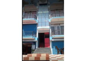 niebieski budynek ze schodami i czerwonymi drzwiami w obiekcie Mountain Facing Rooms in Shimla w mieście Shimla
