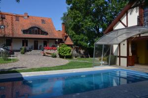 a swimming pool in front of a house at Dworek Mazurski Lizer in Stręgielek