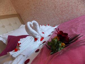 Una cama con dos cisnes envueltos en toallas y flores en Studios Kentia, en Skala Marion