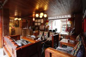a living room with couches and a table and chairs at Chen Jie Inn in Lijiang