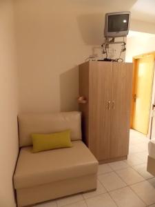 a couch with a yellow pillow in a living room at Studios Kentia in Skala Marion