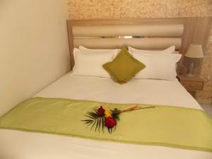 a white bed with a flower decoration on it at Studios Kentia in Skala Marion