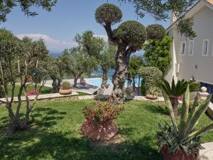 a garden with trees and plants and a building at Golden July Luxury Villa in Akrotiri