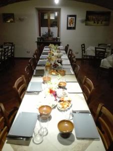 una mesa larga con platos de comida. en Cascina Trapella, en Terruggia