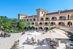 a courtyard with tables and chairs and a building at Le Chateau Lambousa in Kérynia