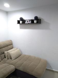 a couch in a room with a white wall at Nadrah Cottage in Bayan Lepas