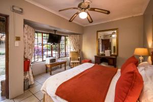 a bedroom with a large bed with a ceiling fan at Warrens Guest House in Hillcrest