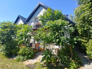 a house with a balcony and trees in front of it at PSZCZÓŁKA in Białogóra