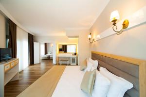 a hotel room with a bed and a television at As Hotel Cesme in Çeşme