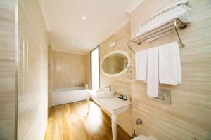 a bathroom with a sink and a mirror and a tub at As Hotel Cesme in Cesme
