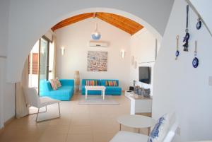 a living room with a blue couch and a table at Narcissos Villa Thekla in Ayia Napa