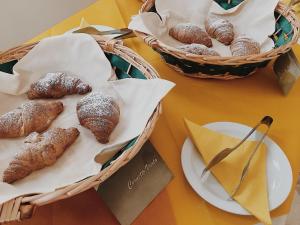 una tavola con due cesti di prodotti da forno e piatti di ciambelle di Family Village Otranto ad Alimini