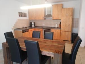 kuchnia z drewnianym stołem i czarnymi krzesłami w obiekcie Villa Zerava Nin w mieście Dračevac Ninski