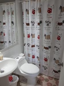 a bathroom with a toilet and a shower curtain with bugs at Departamento Alejandra in El Tabo