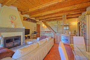 een woonkamer met een bank en een open haard bij Villa Margherita by PosarelliVillas in Piegaio