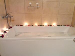 a white bath tub with candles in a bathroom at Apartments Mestrovic in Lopar