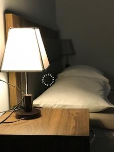 lampa na stole obok łóżka w obiekcie Aleon Hotel w mieście Tbilisi City